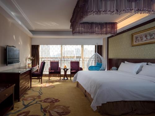 a hotel room with a bed and a large window at Vienna International Hotel Changzhou Hutang in Changzhou