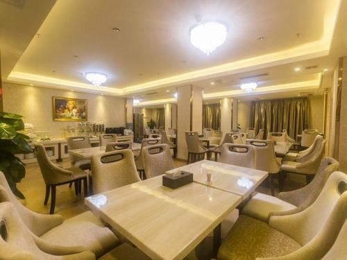 a restaurant with tables and chairs in a room at Vienna Hotel Sanya Yalong Bay Qianguqing in Sanya
