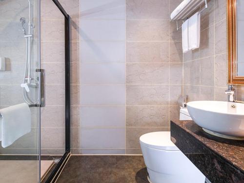 a bathroom with a sink and a toilet and a shower at Vienna Hotel Shenzhen Gongming Bus Station in Kung-ming