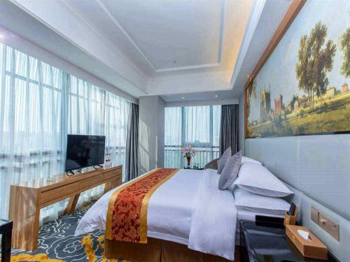 - une chambre avec un grand lit et une grande fenêtre dans l'établissement Vienna Hotel Dongguan East Bus Station, à Dongguan