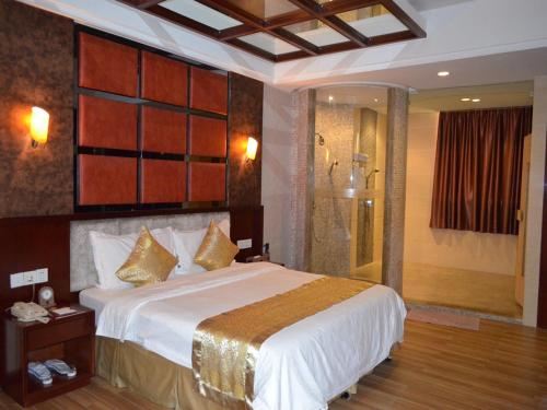 a bedroom with a large bed and a shower at Vienna Hotel Dongguan Tangxia Guanlan Lake Golf Club in Dongguan