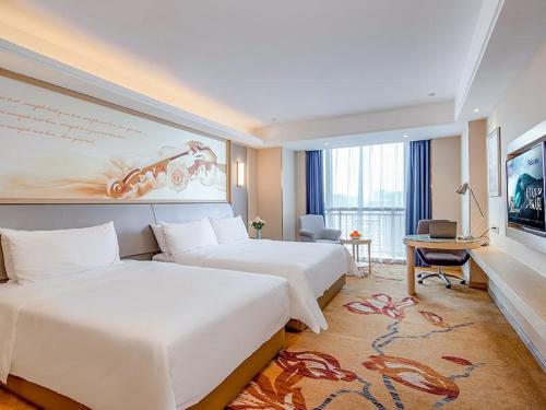 a hotel room with two beds and a television at Vienna International Hotel (Jiaxing Nanhu Hotel) in Jiaxing