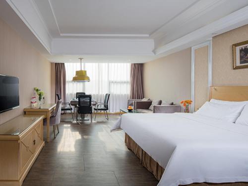 a hotel room with a large bed and a living room at Vienna Hotel Guangzhou South Panyu Bridge in Guangzhou