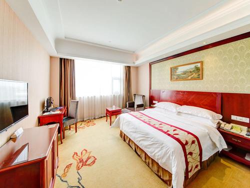 Habitación de hotel con cama grande y TV en Vienna Hotel Shanghai Jiading New City, en Shanghái