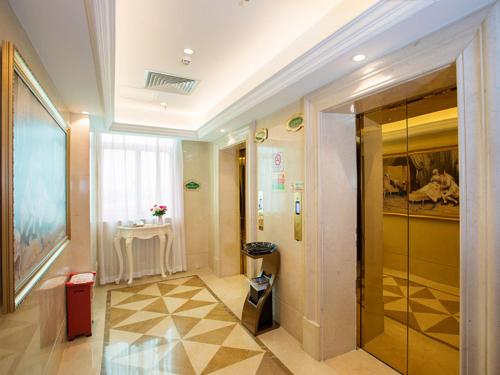 um corredor com uma porta de vidro num edifício em Vienna Hotel Huizhou Railway Station em Huizhou
