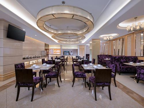 a dining room with tables and chairs in a restaurant at Vienna Hotel Jiangmen Heshan Huamao in Heshan