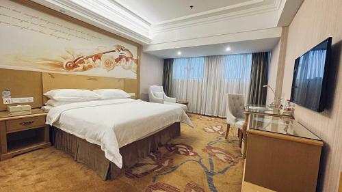 a hotel room with a bed and a flat screen tv at Vienna Hotel Dongguan Shatian Humen Port in Dongguan