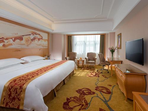 a hotel room with a large bed and a flat screen tv at Vienna Hotel Shenzhen Guangming Guangqiao Road Tianliao in Shenzhen