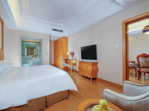 a hotel room with a large bed and a television at Vienna Hotel Chengdu Wenjiang Zhujiang Plaza in Wenjiang