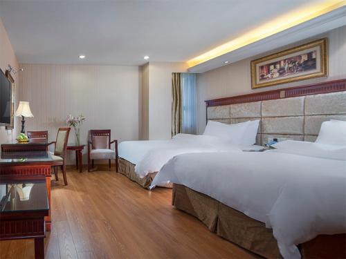 a large hotel room with two beds and a desk at Vienna International Hotel Yangshuo West Street in Yangshuo