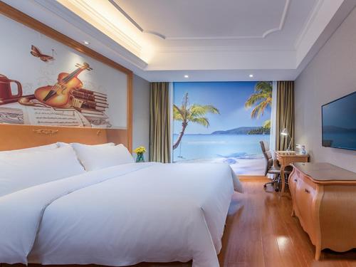 広州市にあるVienna International Hotel Guangzhou Changlong Qifu Xincunのベッドルーム(大きな白いベッド1台、大きな窓付)