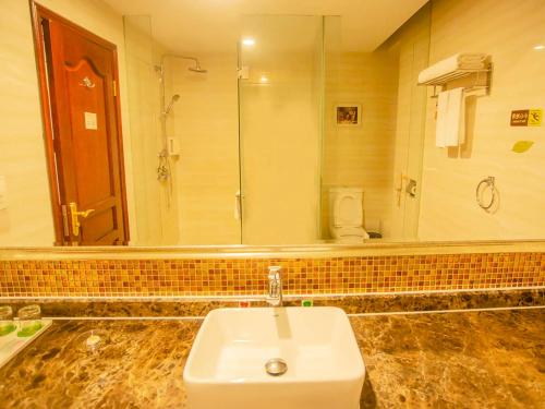 宝安にあるVienna Hotel Shenzhen Songgang Liye Roadの洗面台と大きな鏡のあるバスルーム