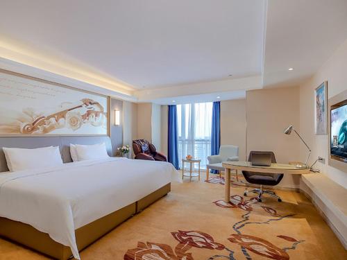 a hotel room with a large bed and a desk at Vienna International Hotel (Jiaxing Nanhu Hotel) in Jiaxing