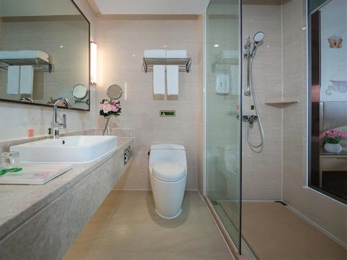a bathroom with a toilet and a sink and a shower at Vienna Hotels(JingHong BinJiang JunJuan) in Jinghong