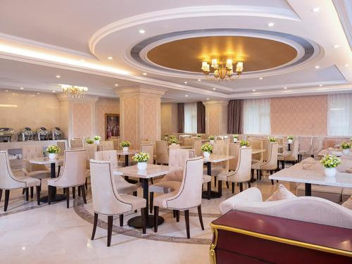 a restaurant with tables and chairs in a room at Vienna Hotel Chaoyang High-Speed Train Station in Shantou