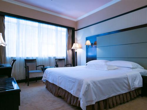 a hotel room with a large bed and a large window at Vienna Hotel Shenzhen Fuhua Road in Shenzhen