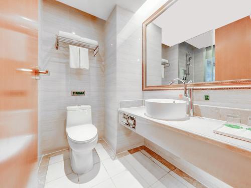 a bathroom with a toilet and a sink and a mirror at Vienna Hotel Wuhan Yellow Crane Tower in Wuhan