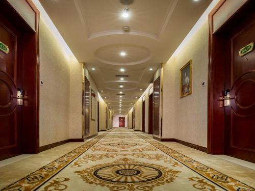 a hallway of a building with a rug on the floor at Vienna Hotel Shunde Longjia Exhibition Center in Shunde
