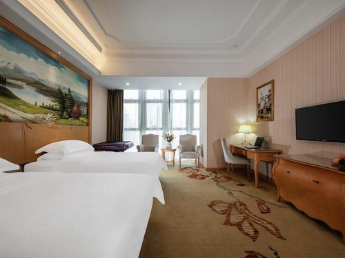 ein Hotelzimmer mit 2 Betten und einem Flachbild-TV in der Unterkunft Vienna International Hotel Fuzhou Cangshan Wanda in Fuzhou