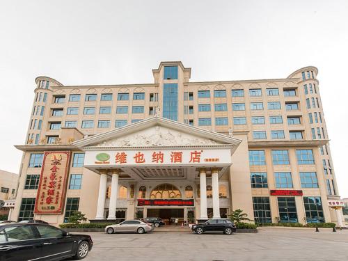 宝安にあるVienna Hotel Shenzhen View Lake Parkの車が目の前に停まった大きな建物