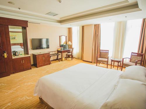 a large hotel room with a bed and a television at Vienna Hotel Dongying Taihangshan Road in Dongying