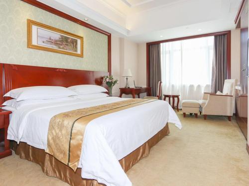 a hotel room with a large bed and a large window at Vienna Hotel Ningbo Ninghai in Shang-ts'un