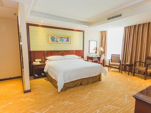 a bedroom with a large bed in a hotel room at Vienna Hotel Dongying Taihangshan Road in Dongying