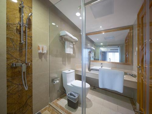 ein Bad mit einem WC und einer Glasdusche in der Unterkunft Vienna International Hotel Nanjing Hehai University Station in Zhucun