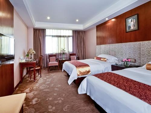 a hotel room with two beds and a desk at Vienna Hotel Nanning Jiangnan Wanda in Nanning