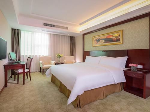 a large white bed in a hotel room at Vienna Hotel Shenzhen BaoAn Qianjin Road in Bao'an