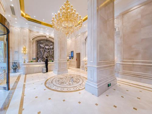 a large lobby with a chandelier and a man standing in it at Vienna Hotel Wuhan Panlong City in Wuhan
