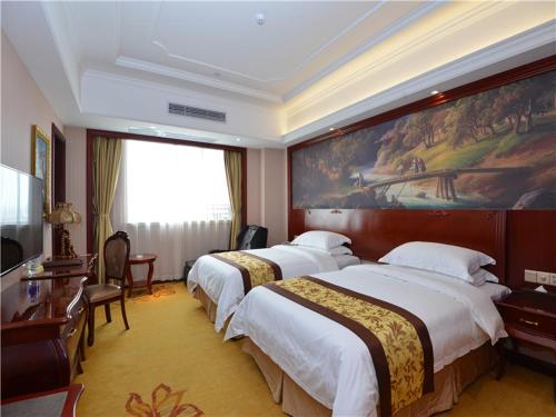 Giường trong phòng chung tại Vienna International Hotel Shanghai International Tourism and Resorts Zone