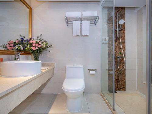 a bathroom with a toilet and a sink and a shower at Vienna Classic Hotel (Anlu Hengkun) in Zhulin