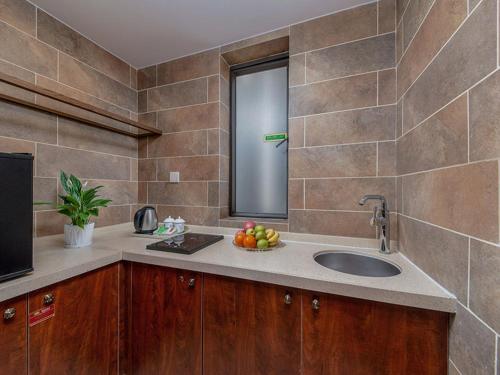 una cocina con fregadero y un bol de fruta en Vienna Hotel Shenzhen Henggang New City, en Longgang