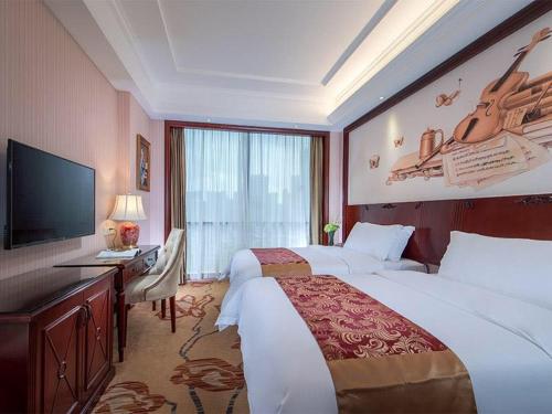 Una habitación de hotel con una cama grande y un televisor. en Vienna Hotel Shenzhen Longzhu, en Shenzhen