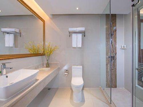 a bathroom with a toilet and a sink and a shower at Vienna International Hotel Dongguan Chang'an North Station in Dongguan