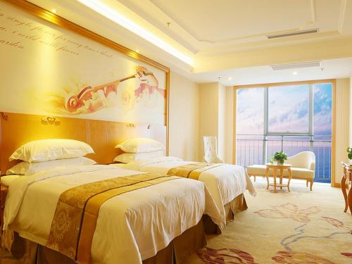 Ένα ή περισσότερα κρεβάτια σε δωμάτιο στο Vienna International Hotel Yantai Changjiang Road Xingyi Square Branch