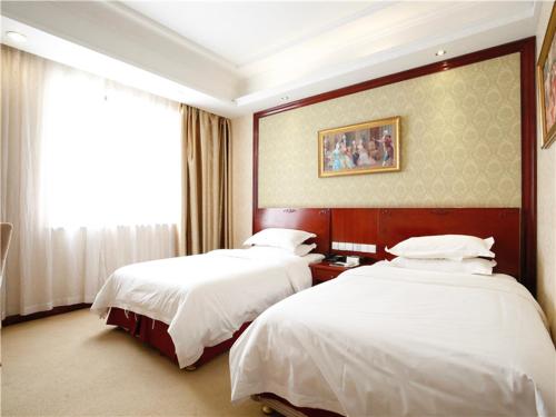 ein Hotelzimmer mit zwei Betten und einem Fenster in der Unterkunft Vienna Hotel Suzhou Luokou Furniture Store in Suzhou