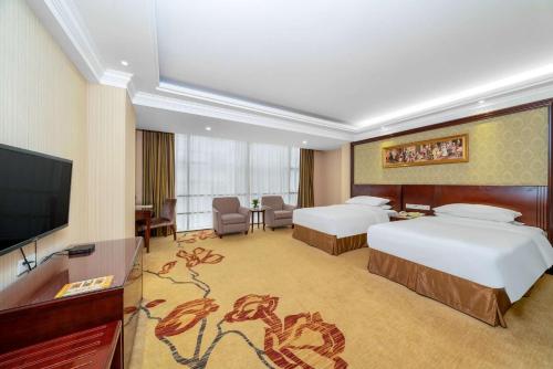 Habitación de hotel con 2 camas y TV de pantalla plana. en Vienna Hotel Dongguan Houjie Exhibition Center, en Dongguan