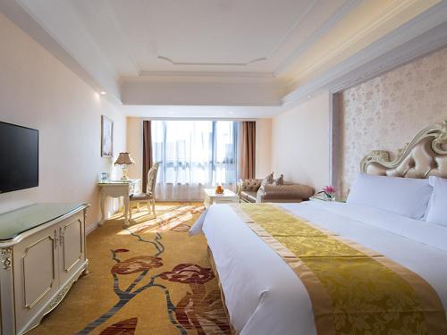 a hotel room with a large bed and a television at Vienna International Hotel Jieyang Yangmei Yudu in Jieyang