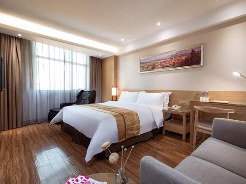 a hotel room with a large bed and a desk at Vienna 3 Best Hotel Shenzhen Pinghu Fumin Road in Longgang
