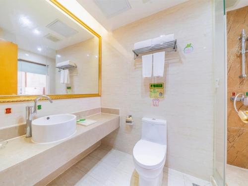 Baño blanco con lavabo y aseo en Vienna Hotel Shiyan Guangming Road, en Bao'an
