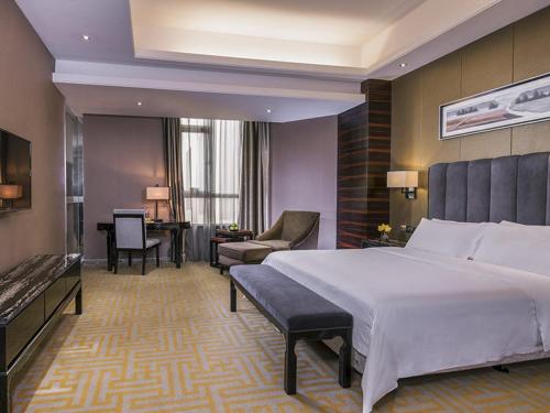 Pokój hotelowy z dużym łóżkiem i biurkiem w obiekcie Vienna Hotel Dongguan Gaobu w mieście Dongguan
