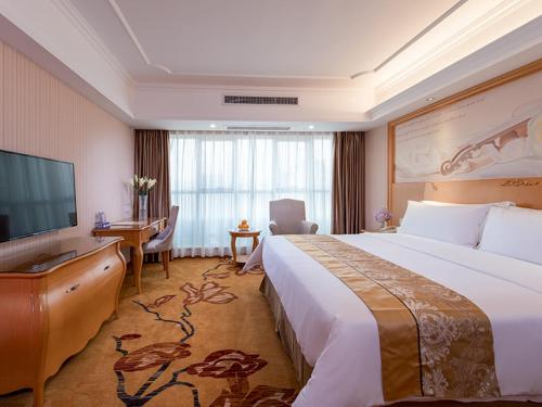 een hotelkamer met een groot bed en een flatscreen-tv bij Vienna Hotel Nanning Gaoxin District in Nanning