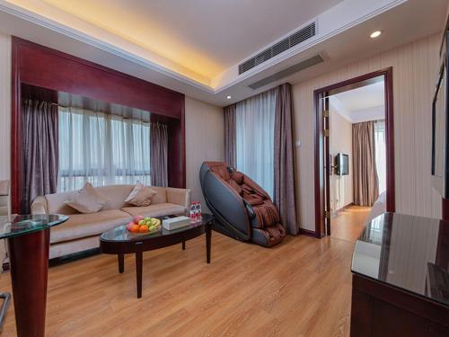 a living room with a couch and a table at Vienna Hotel Shenzhen Henggang New City in Longgang
