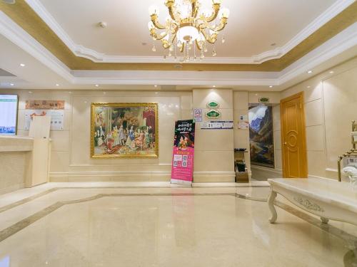 Großes Zimmer mit Kronleuchter in einem Gebäude in der Unterkunft Vienna Hotel Guangzhou Beijing Road in Guangzhou