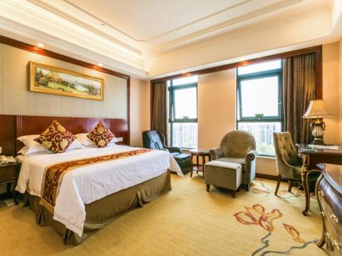 a hotel room with a bed and a desk and chairs at Vienna Hotel Shanghai Hongqiao National Convention and Exhibition Center Wanda in Jiading