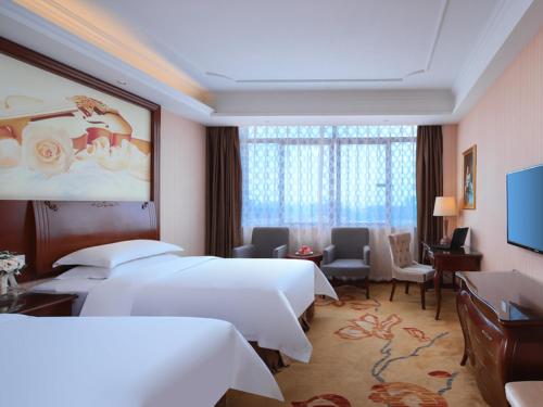 a hotel room with two beds and a desk at Vienna Classic Hotel Nanchang Jiefang West Road in Nanchang