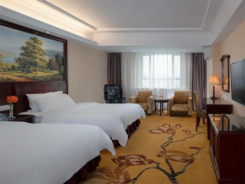 um quarto de hotel com duas camas e uma televisão em Vienna Hotel Dongguan Chang'an Mid Zhen'an Road em Dongguan