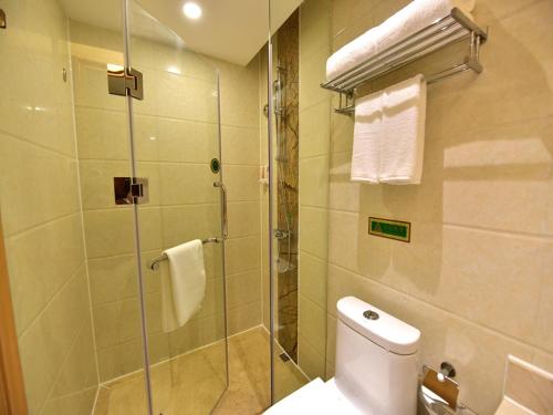 西寧市にあるVienna Hotel Xining Shengli Roadのバスルーム(シャワー、トイレ、ガラス張りのシャワー付)